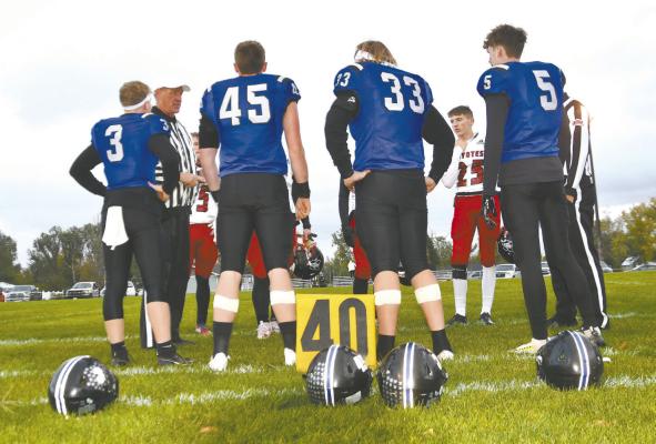 Meeting at the 40-yard line for the Captain's meeting in their last regular season game are Bobcat Seniors: Trey Connell (3), Rio Remund (45), Joey Sallach (33), and Cache Gracey (5). (Leader photos by Loleta Connell)