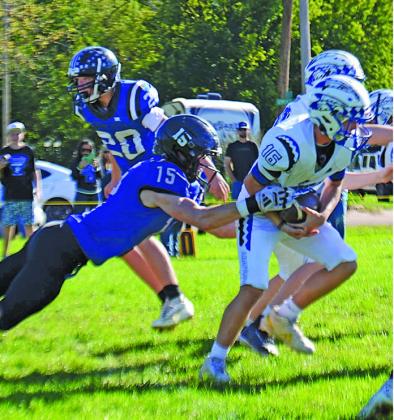 Brady Green (#15) tries to tackle the Arapahoe runner while Cruz Mason (#20) looks to assist.