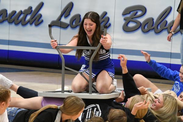 Greeley Hrupek goes table surfing with a little help from the girls at the pep rally Thursday evening