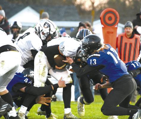 Junior Harper Johnson (#13) reaches for a chance to strip the ball with help from fellow teammates Crew Witthuhn (#44) and Dylan Pandorf (#11). (Courier photos by Loleta Connell)