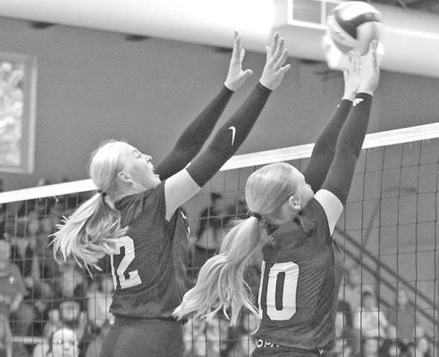 Emma Stallbaumer (#32) and Rae Hagler (#10) work together to defend the Lady Bobcats' side of the net. (Courier photo by Ronda McFate)