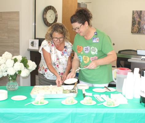Kelly Herbig, left, Program Director for Callaway's Senior Life Solutions, and Janel Brestel, Office Patient Coordinator, served cake during the Open House on May 23. The event marked the culmination of a month of activities for Mental Health Awareness Month in May. (Courier photo by Ellen Mortensen)