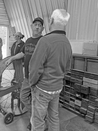 Travis Eastwood (facing camera) visits with Lawrence Paulsen during an open house and ribbon-cutting event celebrating his larger building and paint booth. The Shop is located at 308 S. Woods Ave. in Callaway. (Photo courtesy Kelsey Wyckoff)