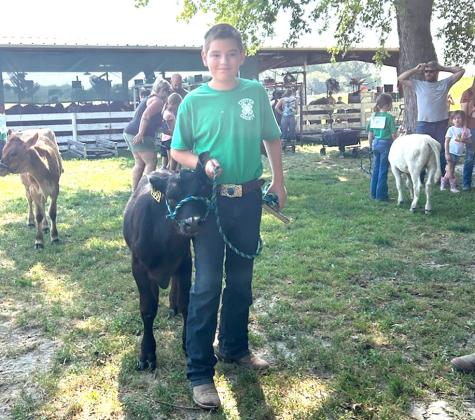 Luke Coleman poses with his bucket calf prior to the Custer County Fair show. (Courier photo by Loleta Connell)