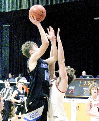 Dylan Pandorf goes up for a shot over the hands of the Cambridge defender on Dec. 13. (Courier photos by Ronda McFate)