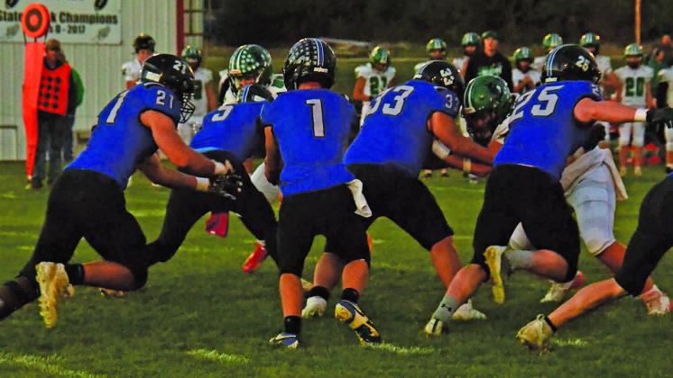 The South Loup offensive line tries to keep the Wolves away as Tysen Schacher (#1) hands the ball off to Noah Anderson (#21). Linemen pictured are Dawson Downing (#5), Taytum Wiese (#33), and Malachi Neth (#25).