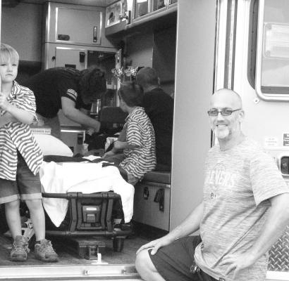 The Village of Callaway recently acquired a new ambulance, and the EMS department took an opportunity to show it off to the public during the 4th of July celebration at the ballpark. Pictured is EMS Captain Mark Buss, while EMT Amber Harrison shows some children around the inside of the new unit. (Courier photo by Ellen Mortensen)