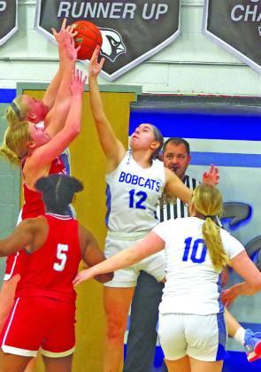 Kamryn Kramer (#12) attempts to block a Hi-Line shot as the Lady Bobcats went on to secure a 10-point win.