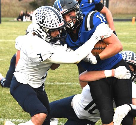 Right: Sophomore Conner Paulsen (#10) secures the ball as Cougar defenders work to strip the ball on the tackle
