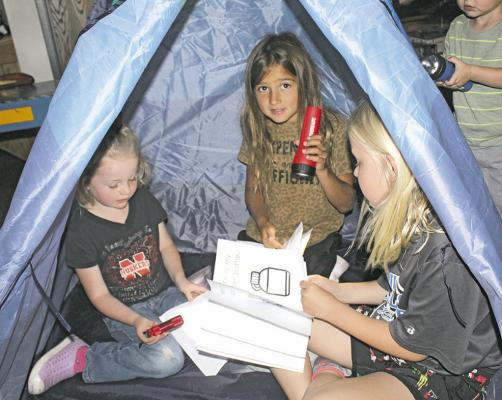 The Callaway library hosts a summer reading program each Monday and Wednesday. Last week's theme was camping, and the kids attending each made their own camping book then read them by flashlight in tents in the library. (Courier photo by Ellen Mortensen)