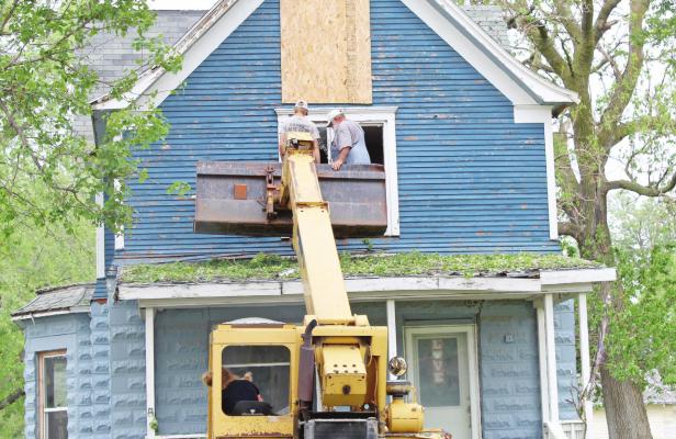Boarding up broken windows was a common sight around Callaway Sunday evening and Monday, following a devastating hail storm that ripped its way through town June 5. (Courier photo by Ellen Mortensen)