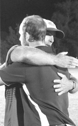 You know it will be a great game with a father versus son match-up like this...Coach Andy Schwarz and Coach Blake Schwarz hug after the game Thursday evening. (Courier photos by Loleta Connell)