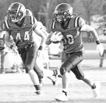 Sophomore Crew Witthuhn watches for the next defender while #10 sophomore Conner Paulsen hits the gap in the Bobcats 48-21 victory over Elm Creek.