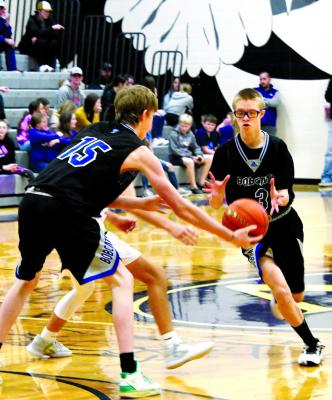 Carter Wood hands off to Caleb McFate as he drives to the bucket and adds two to the Bobcat's 77-47 win over Southern Valley.