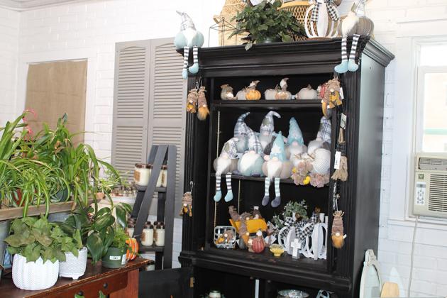 A shelf of fall garden decor and wintery garden gnomes.