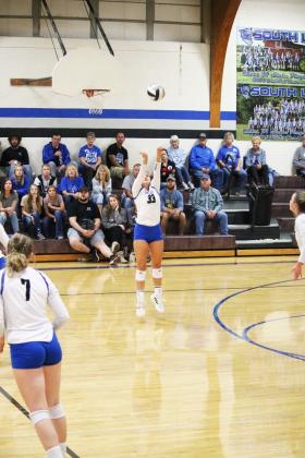 Ava Pandorf is midjump as she sets a volleyball