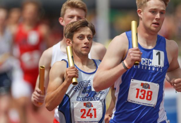Silas Cool keeps his competitor from Hastings St. Cecelia in his sights during Class C 4 x 800 meter relay action. (Courier photo by Corbey Dorsey)