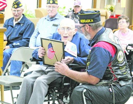 Gene Hendricks of Broken Bow (kneeling) is a charter member of the Central Sandhills Chapter of American Legion Riders. On Sunday, June 8, he presented a certificate of honor for service to US Army veteran Bill Benjamin, a resident of Callaway Good Life Center. (Courier photo by Ellen Mortensen)