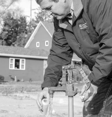 Harold Benton, a Water Resources Technician with the Lower Loup Natural Resources District, takes samples from a domestic well. (Photo courtesy LLNRD)