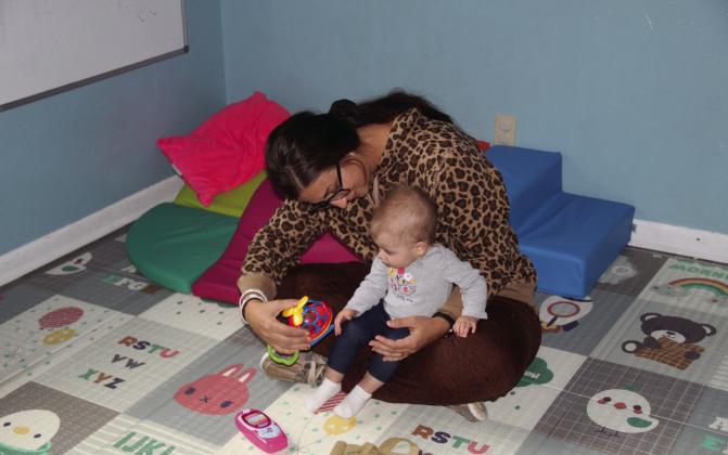 The staff at Homegrown Kids East Daycare, soon to be Little Farmhouse Daycare, spends a lot of time on the floor with the kiddos - as seen here by owner Kayla Berg and Lula. Courier photo by Ellen Mortensen