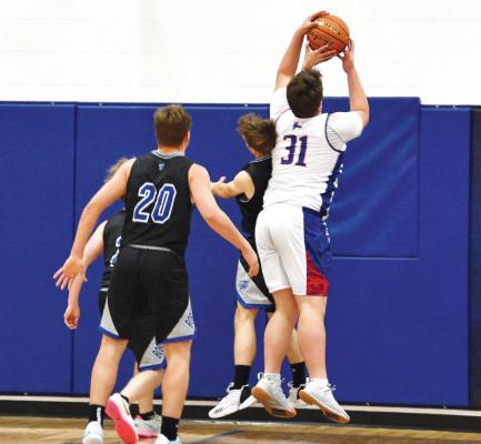 Senior Silas Cool may have been outsized, but he saved the rebound against much bigger Kellen Cole. (Courier photos by Loleta Connell)