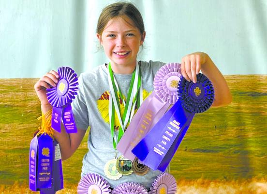 Kennedy Eggleston represented the Tail Twisters 4-H club at the fair and poses with all of her hardware at the end of the week. (Photo courtesy Melissa Eggleston)