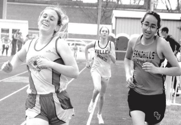 Tallianna Martin's smile says it all as she not only breaks the school record, but the MNAC meet record as well, clocking a 5:39 in the 1 mile run. (Courier photo by Loleta Connell)