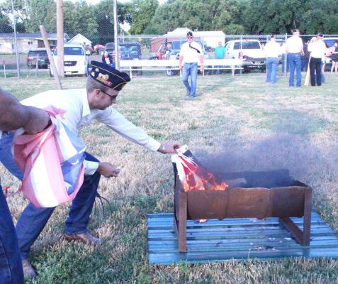 More than 60 worn and tattered American flags were properly disposed of during a ceremony at the ball field in Callaway on July 4. (Courier file photos)