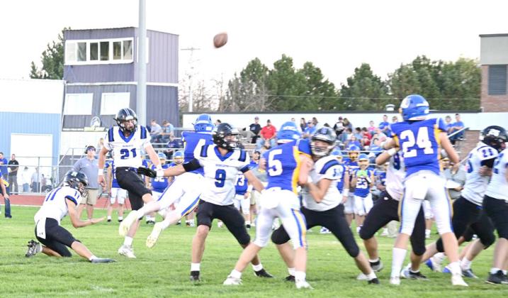 ABOVE: Paxton Bierman helps Harper Johnson tackle a Husky with Jamie Tickle and Ethan Furne by their side. LEFT: Jamie Tickle kicks a good field goal for a point during game against West Holt. (Courier photos by Jessica Tickle)