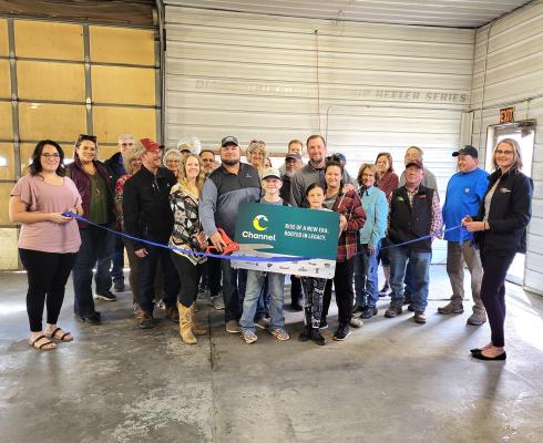 Customers, friends, family, and community members joined owners TR Anderson and Abe Hinman as the ribbon was cut on their new location on Grand Ave. on Monday, Feb. 26. (Courier photo by Ellen Mortensen)