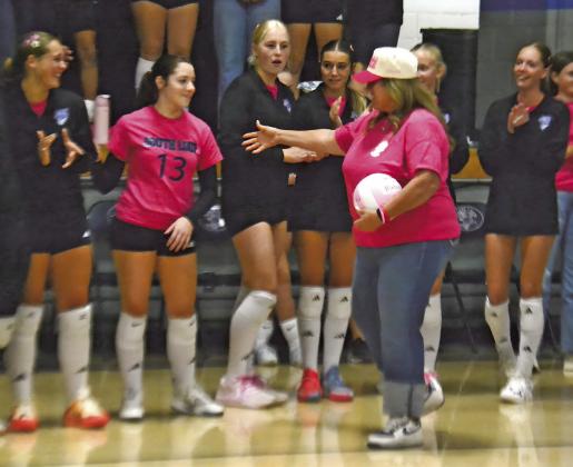 Holly Hornung Remund greets the South Loup volleyball team who are all wearing pink “Riata’s Ripple” shirts in honor of her daughter.