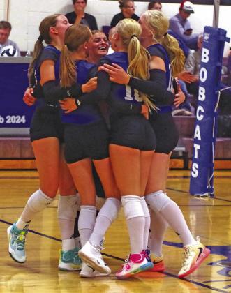 The Lady Bobcats come together to celebrate winning the point.