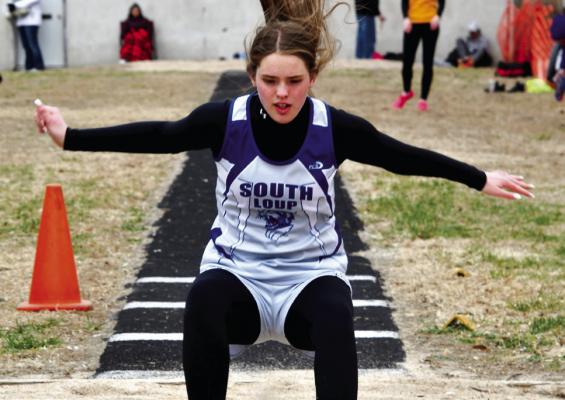 Aubree Birkel leaps to 12'1' in the long jump on a windy Friday in Burwell.